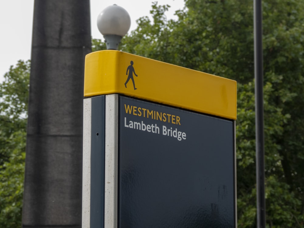 yellow and black signage near gray post