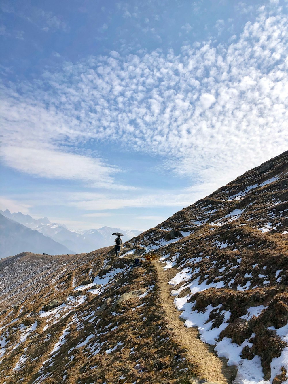 person standing on snow covered mountain during daytime