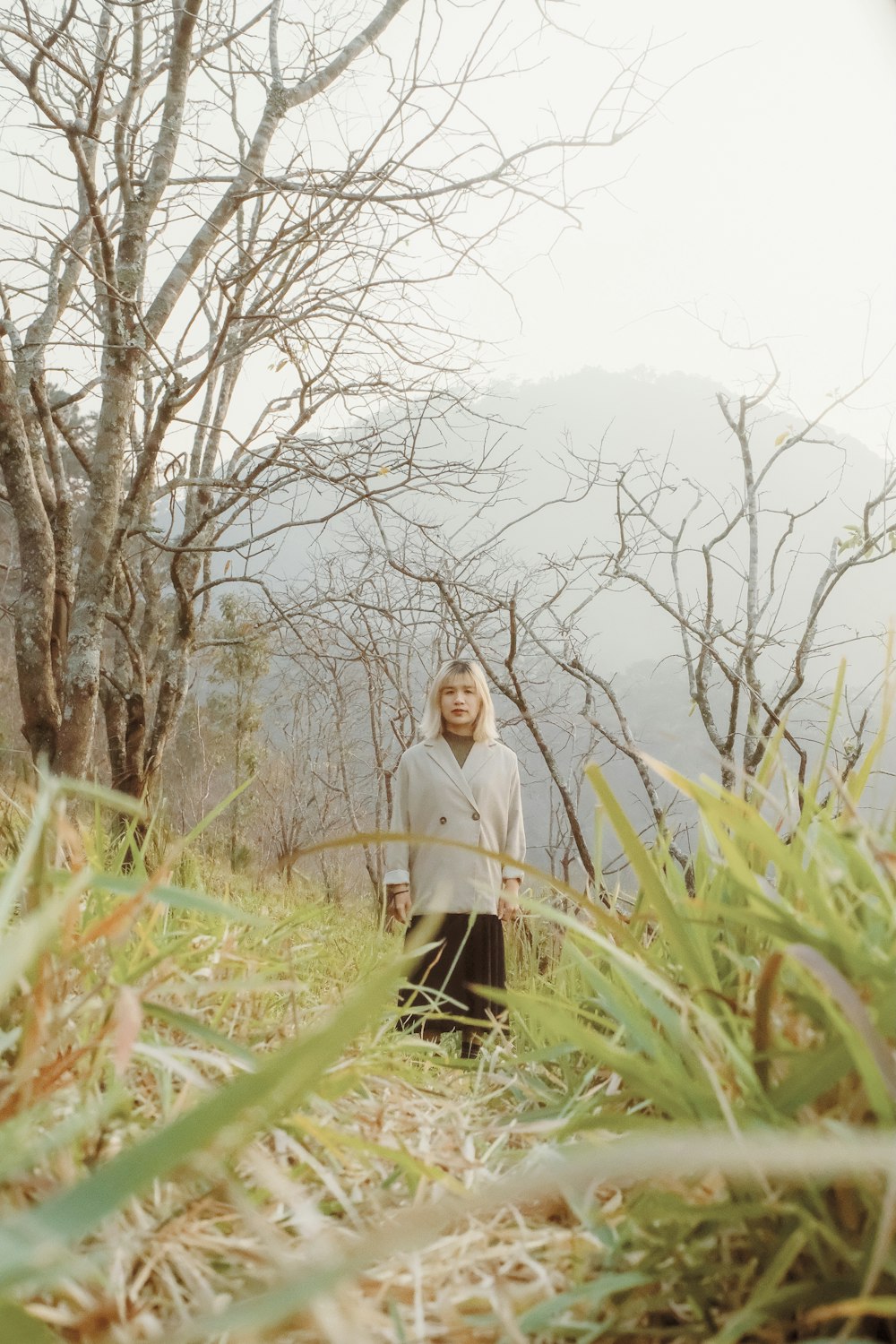 woman in white long sleeve shirt standing on green grass field during daytime