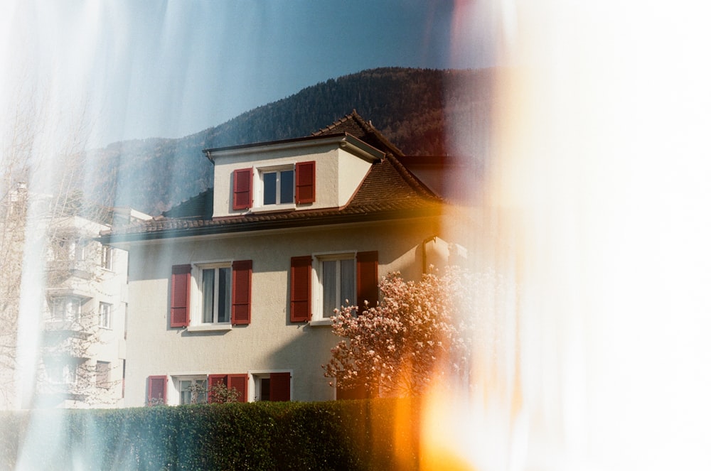 white and brown concrete house near green trees during daytime