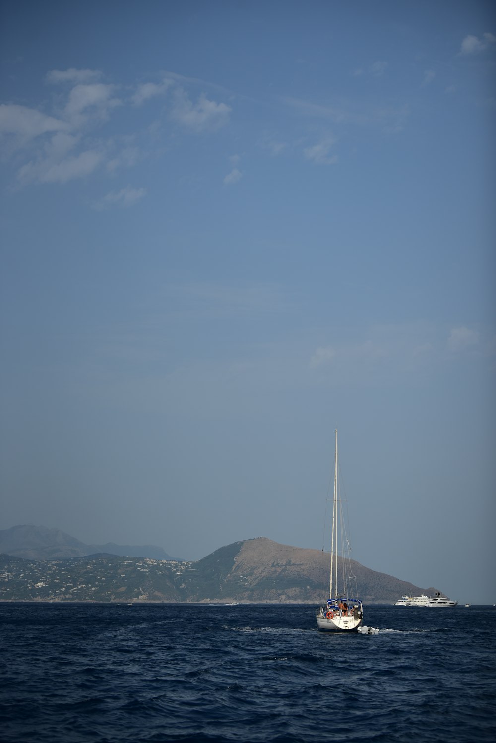 white sailboat on sea under blue sky during daytime