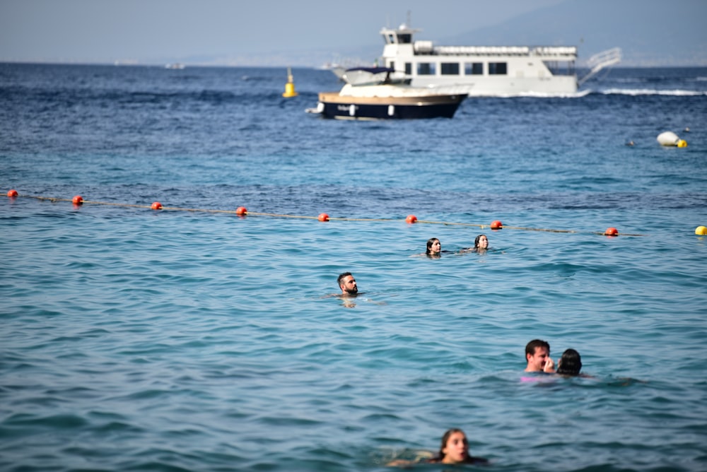 people swimming on sea during daytime