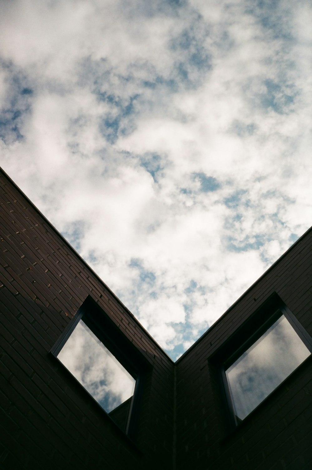 brown brick building under white clouds during daytime