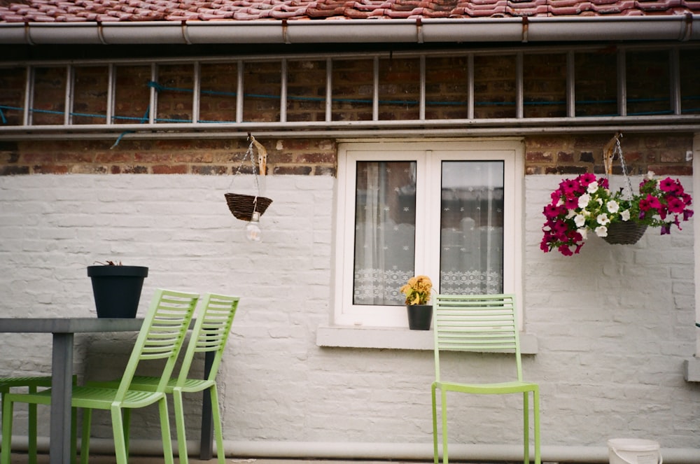 green plastic armchair beside white wooden framed glass window