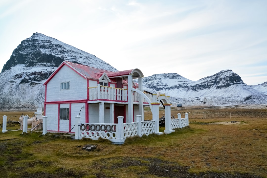 white and red wooden house near mountain during daytime