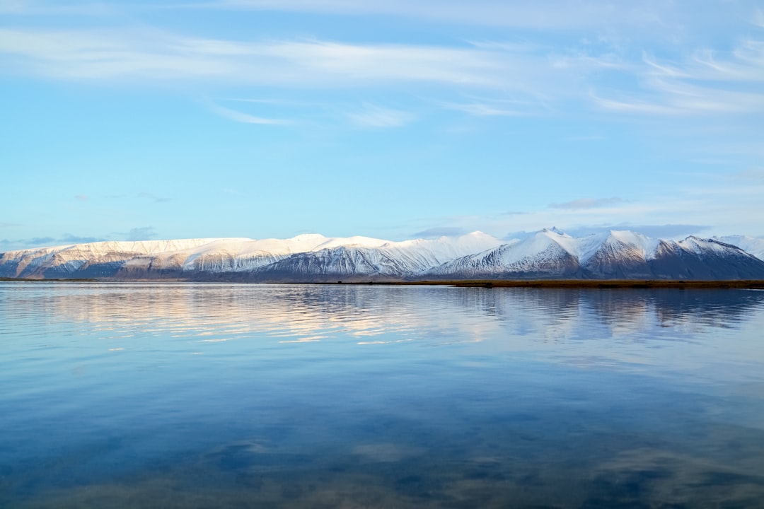 lake near snow covered mountains under blue sky during daytime