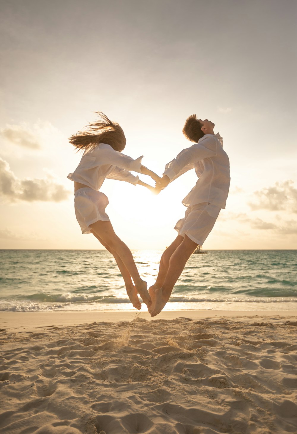 man and woman kissing on beach during daytime