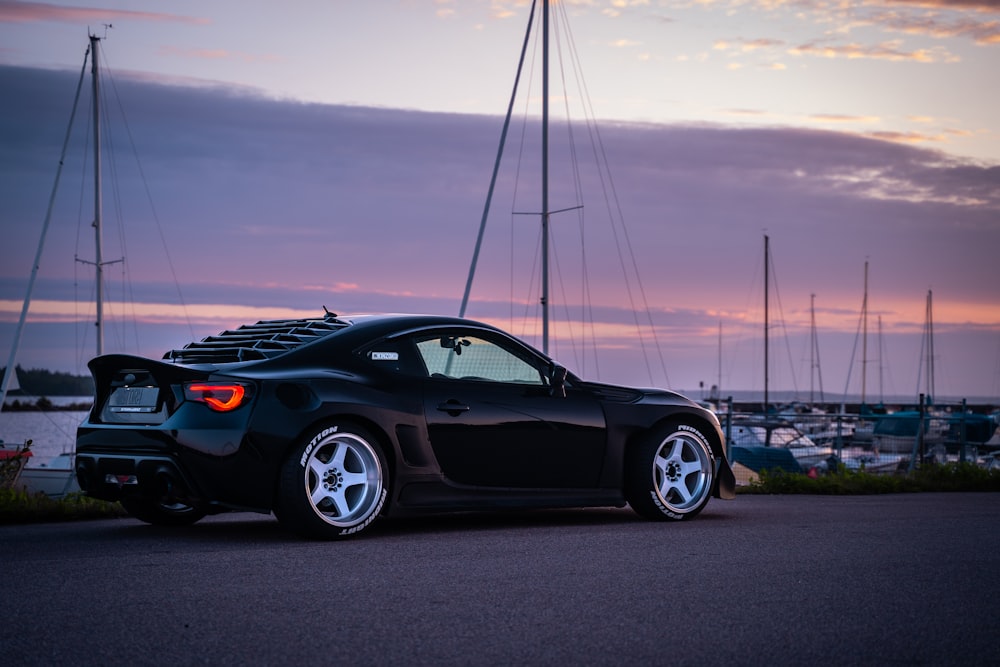 Porsche 911 negro en la carretera bajo un cielo nublado