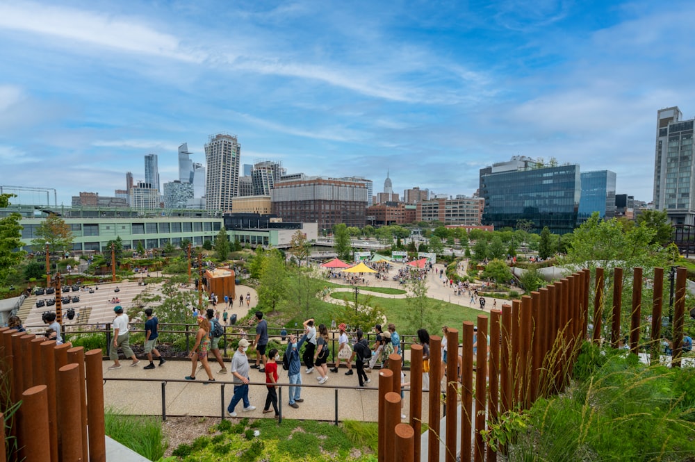 people walking on green grass field near city buildings during daytime