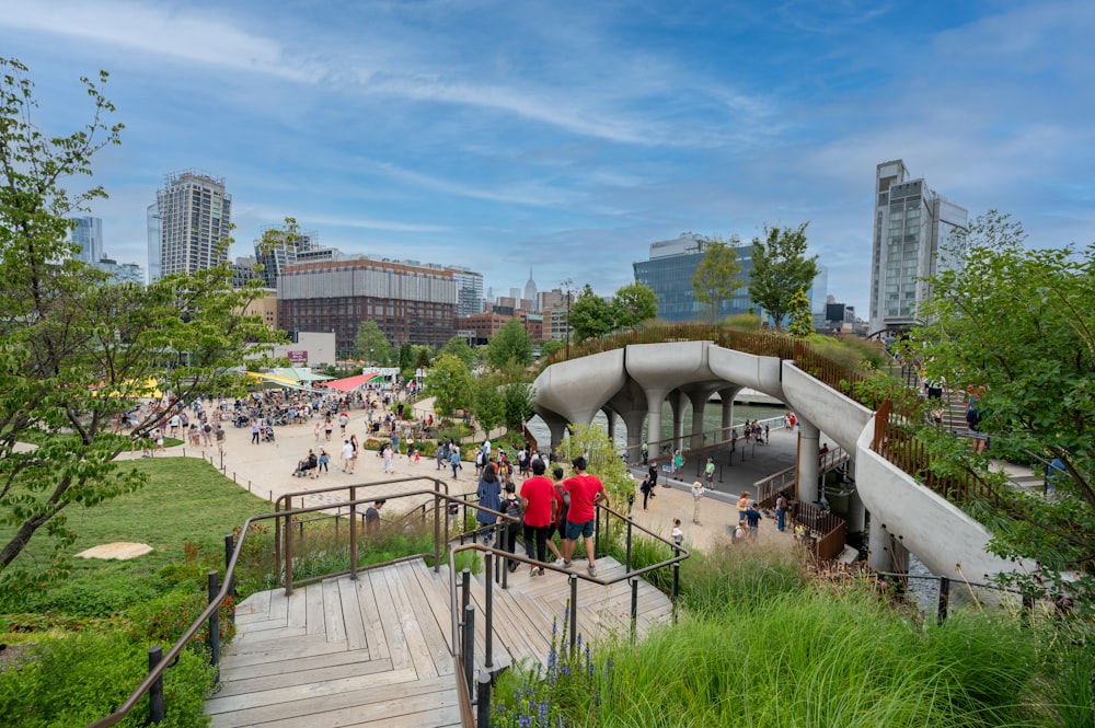 people walking on wooden pathway near buildings during daytime