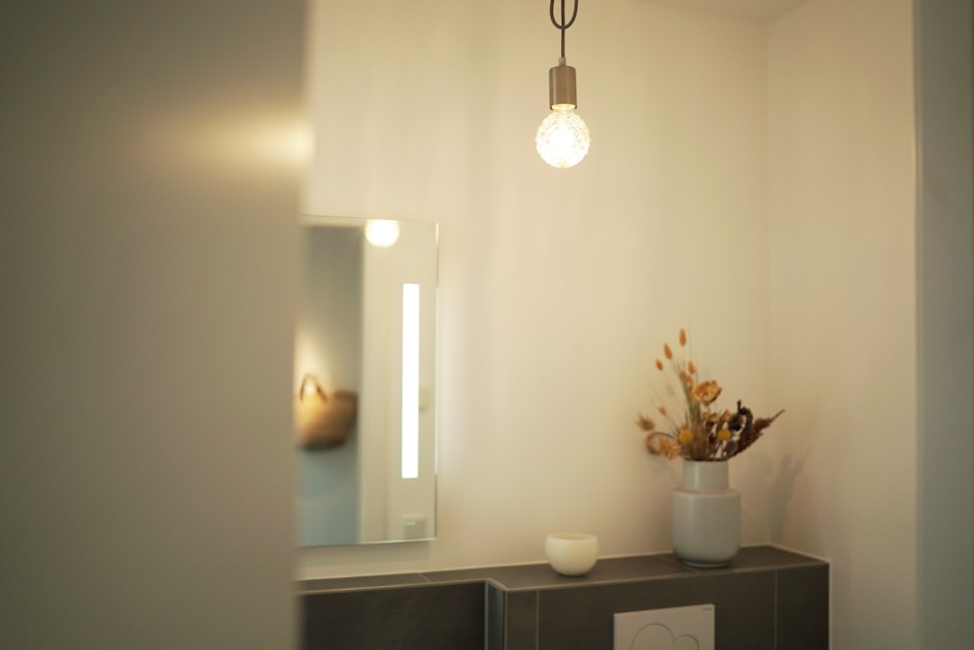 white pendant lamp turned on near white wooden cabinet