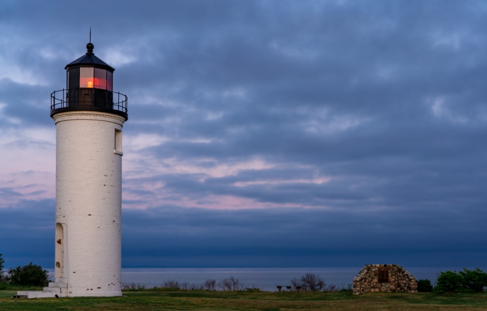 white and red lighthouse under cloudy sky during daytime