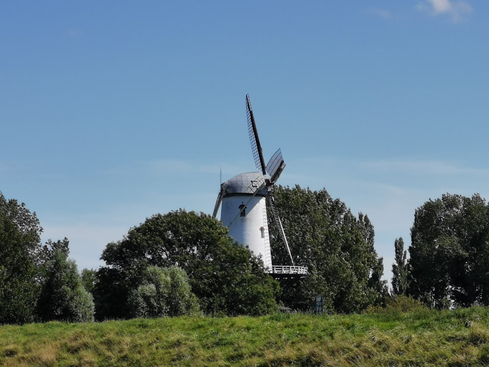 white windmill on green grass field during daytime