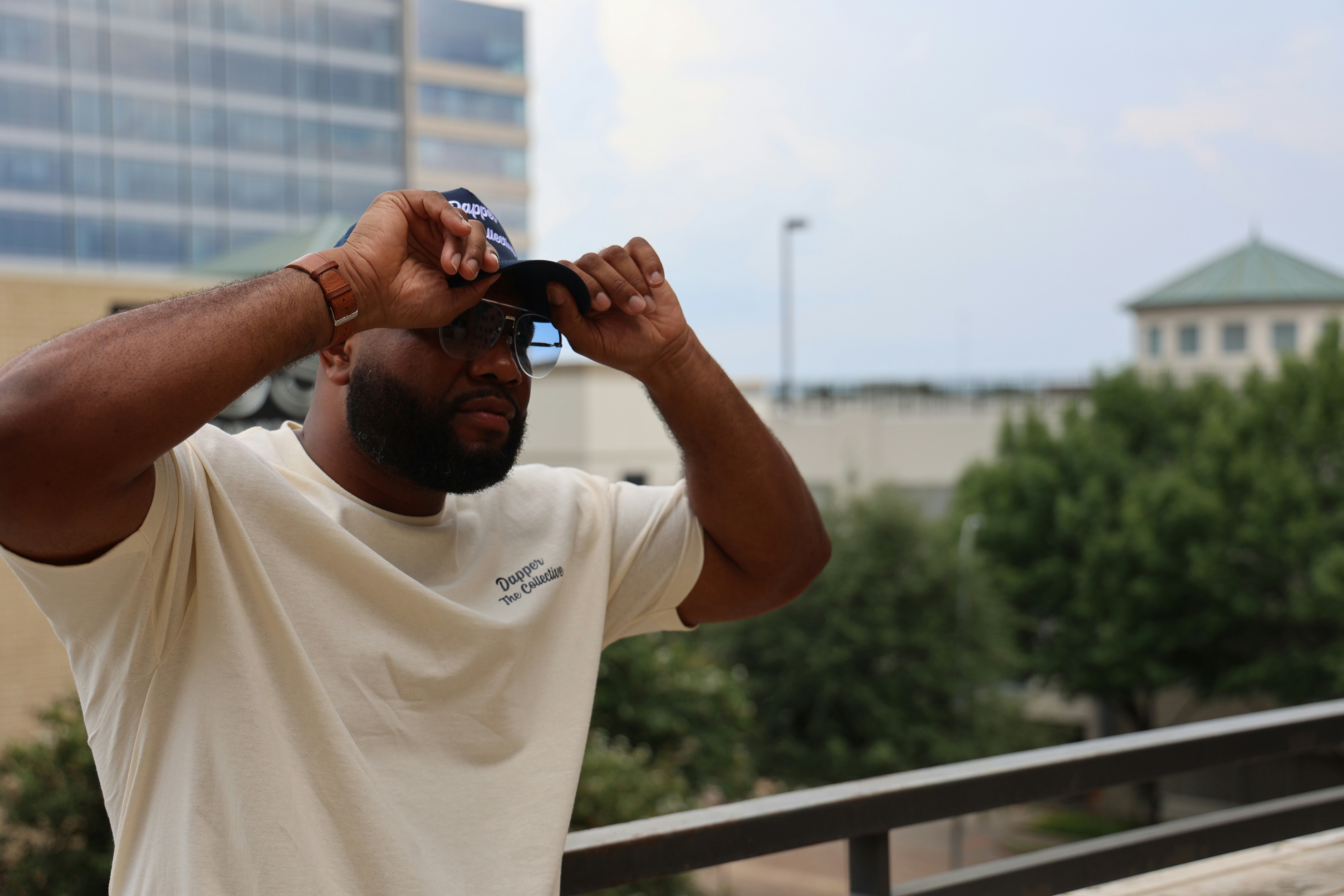 黒いサングラスをかけた白いクルーネックTシャツの男