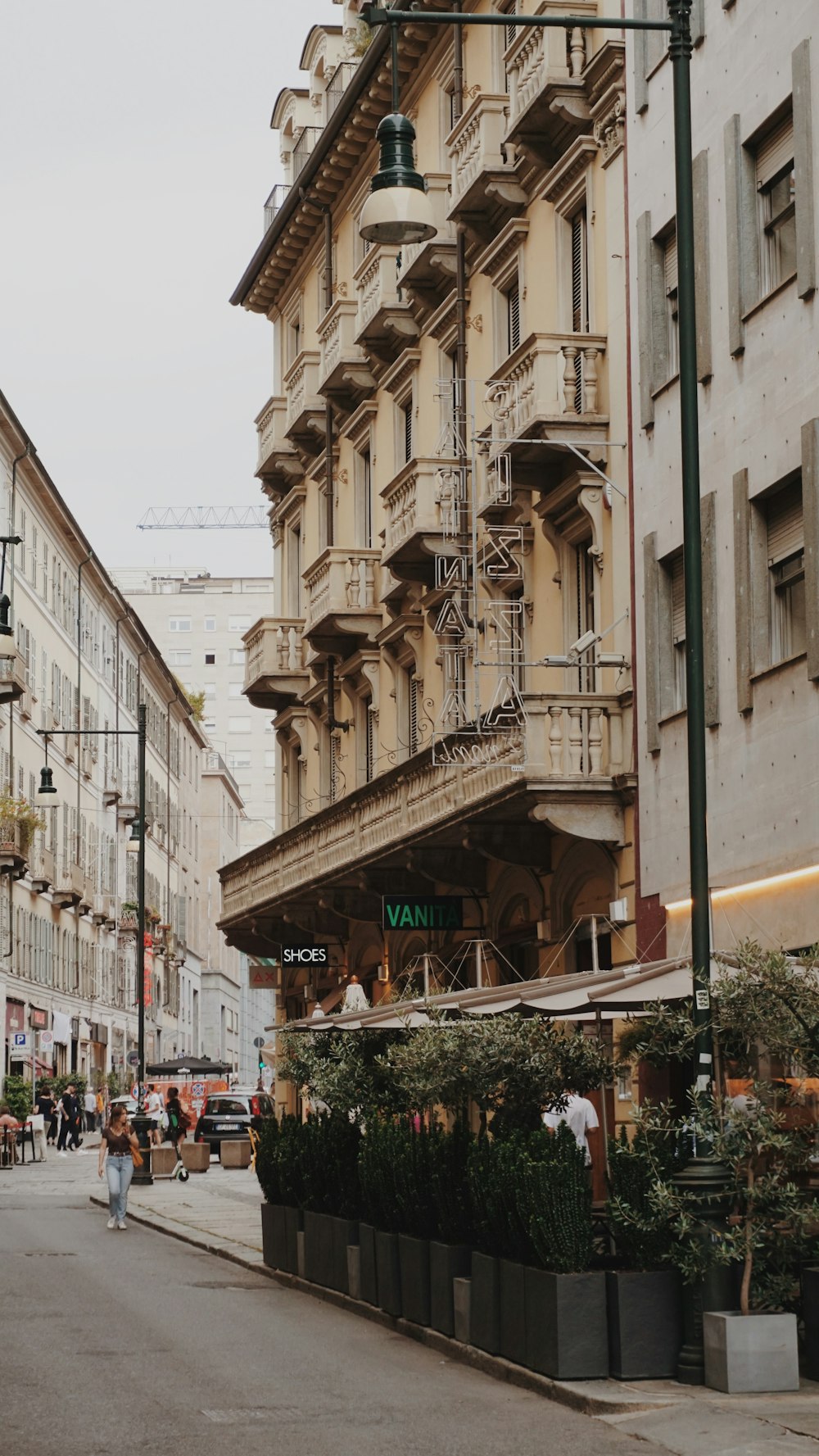 pessoas andando na rua perto de edifício de concreto branco durante o dia