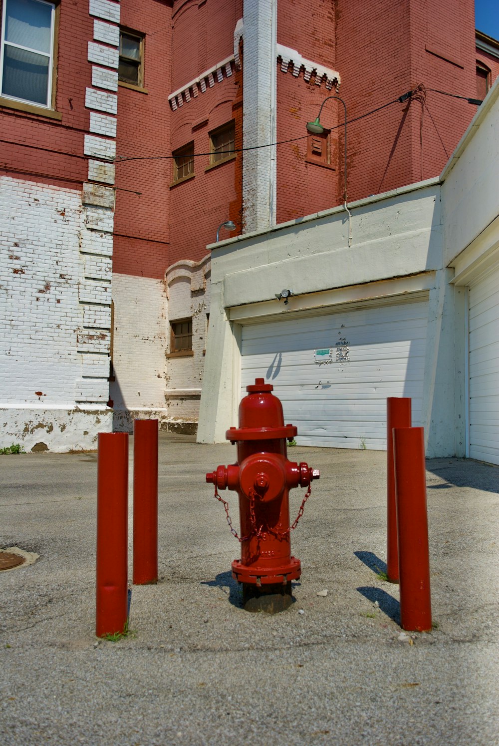 red fire hydrant near white and red concrete building during daytime