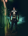 man in black and white crew neck t-shirt and blue denim jeans standing beside neon