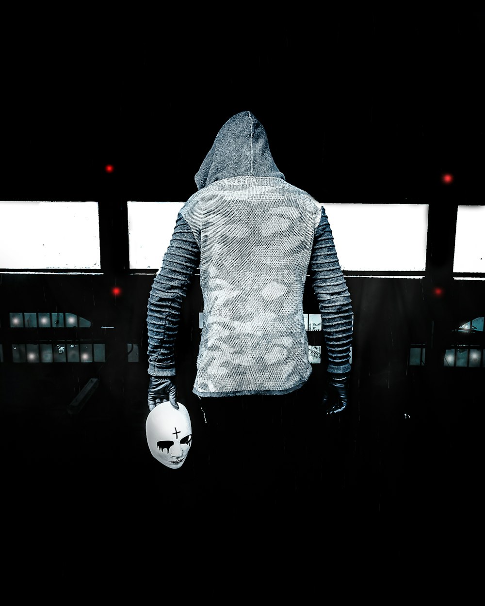 person in gray hoodie standing on black floor