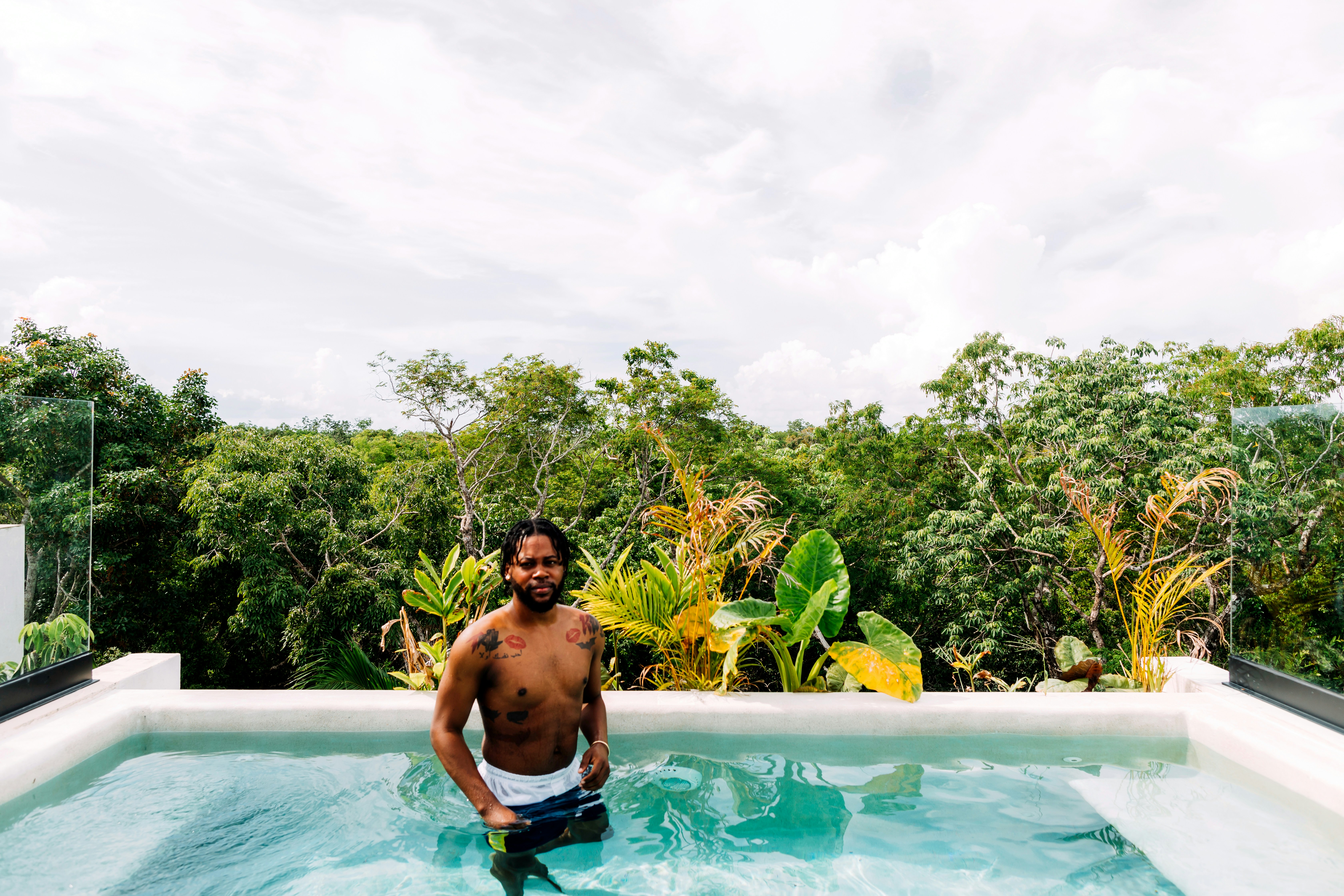 man in blue shorts in swimming pool during daytime