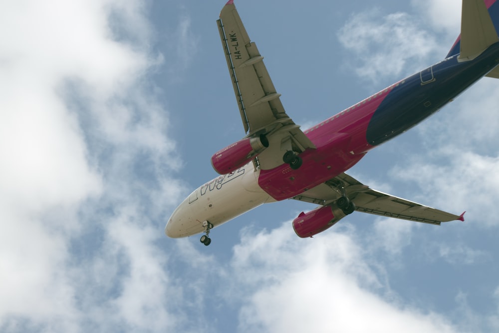 white and red passenger plane flying in the sky during daytime