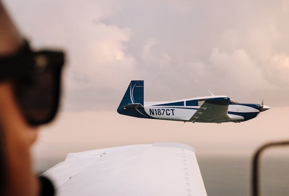 blue and white airplane flying during daytime