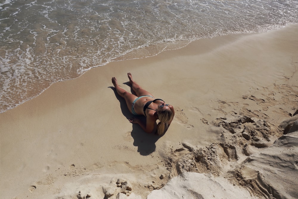 woman in black bikini lying on beach