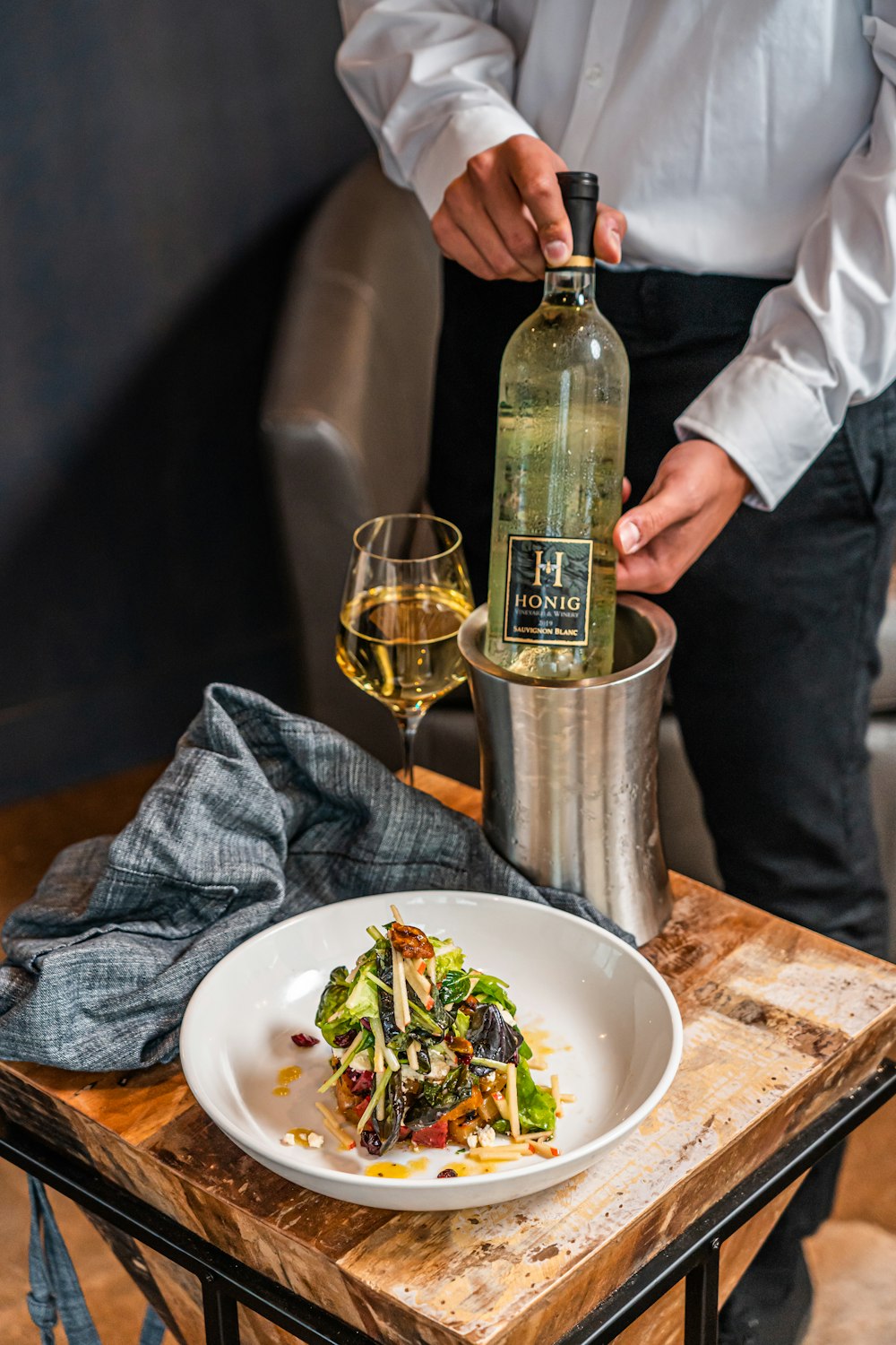 a man pouring a glass of wine into a plate of food