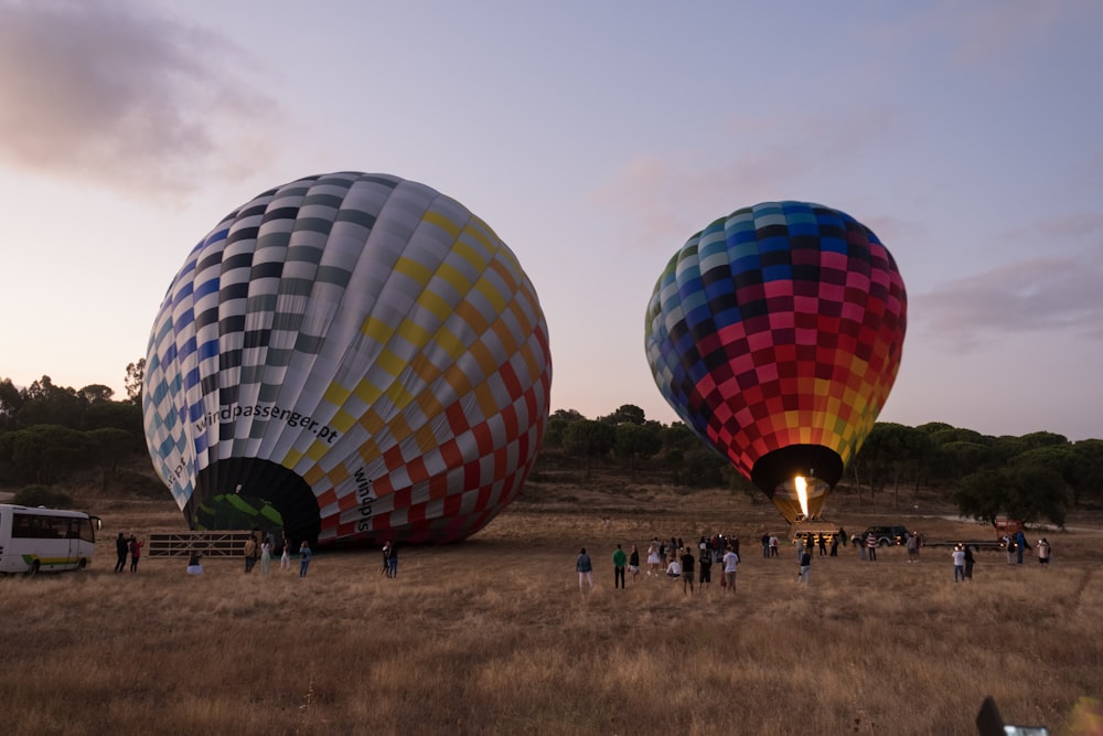 people standing near red blue and yellow hot air balloon during daytime