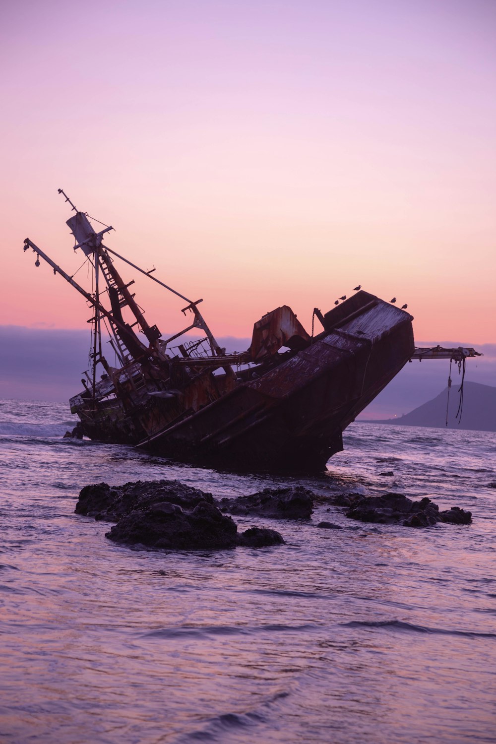 Braunes Schiff auf See bei Sonnenuntergang