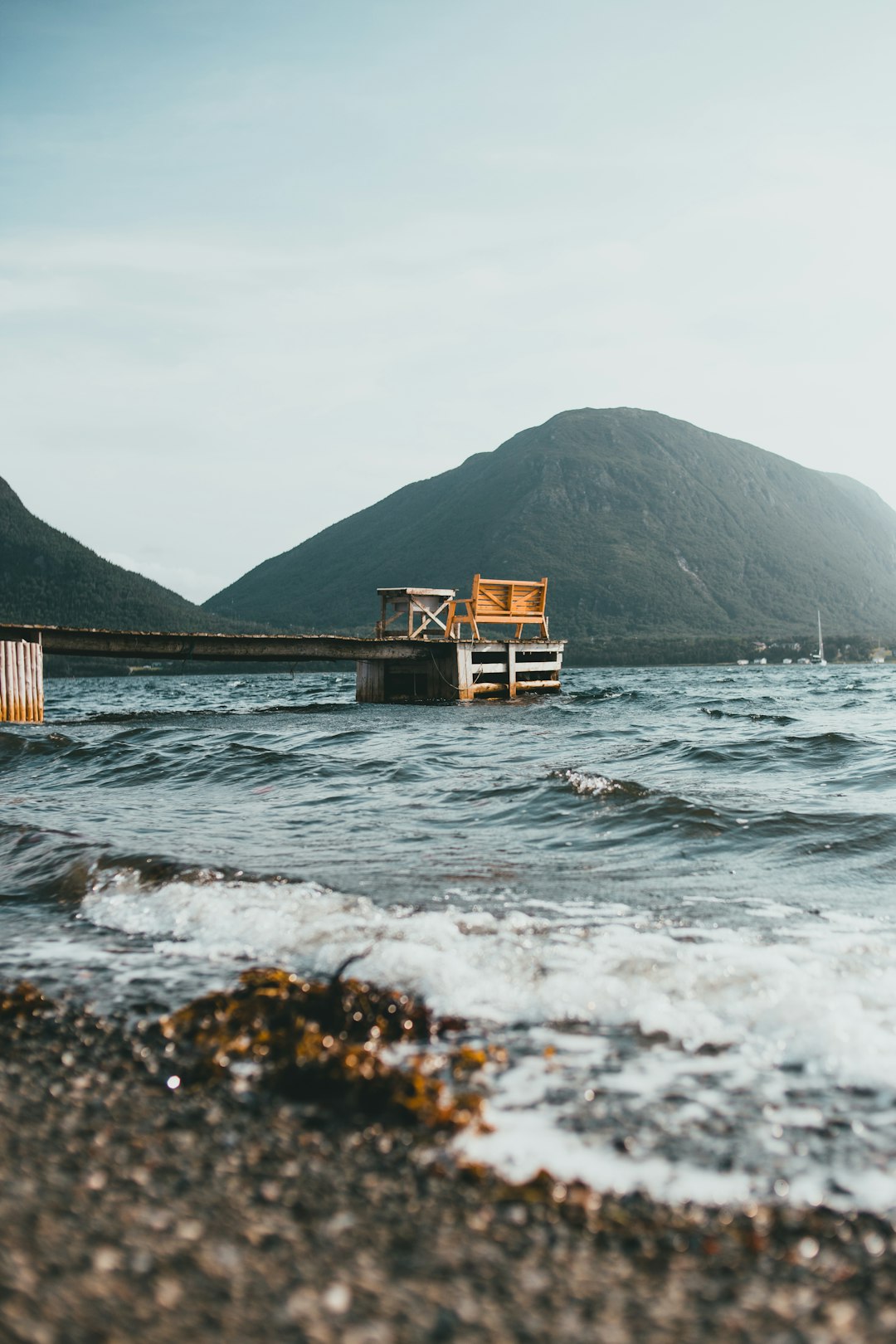 brown wooden house on brown rock formation near body of water during daytime