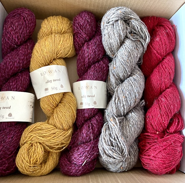 Branded wool skeins laid in a box, like yarn ready for sale on a shop shelf