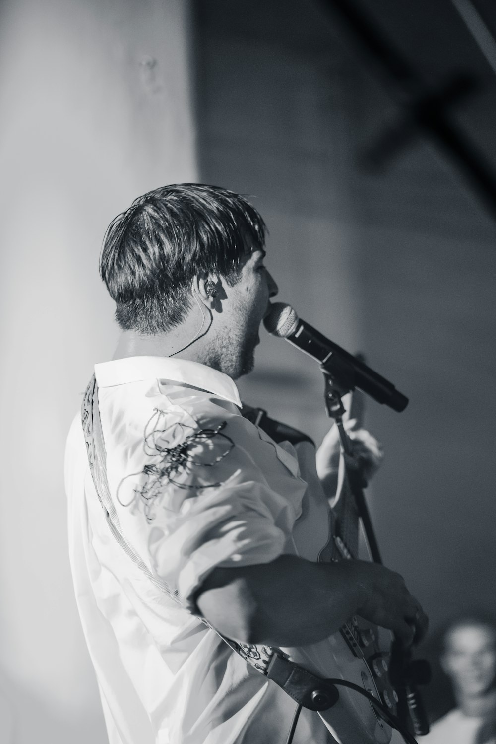 man in white dress shirt singing