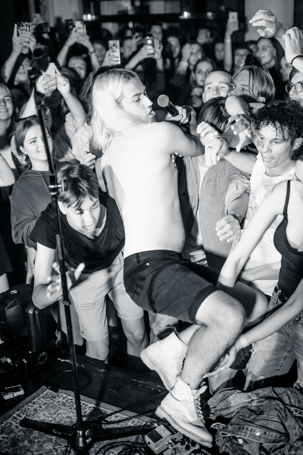 grayscale photo of woman in black tank top and shorts sitting on mans lap