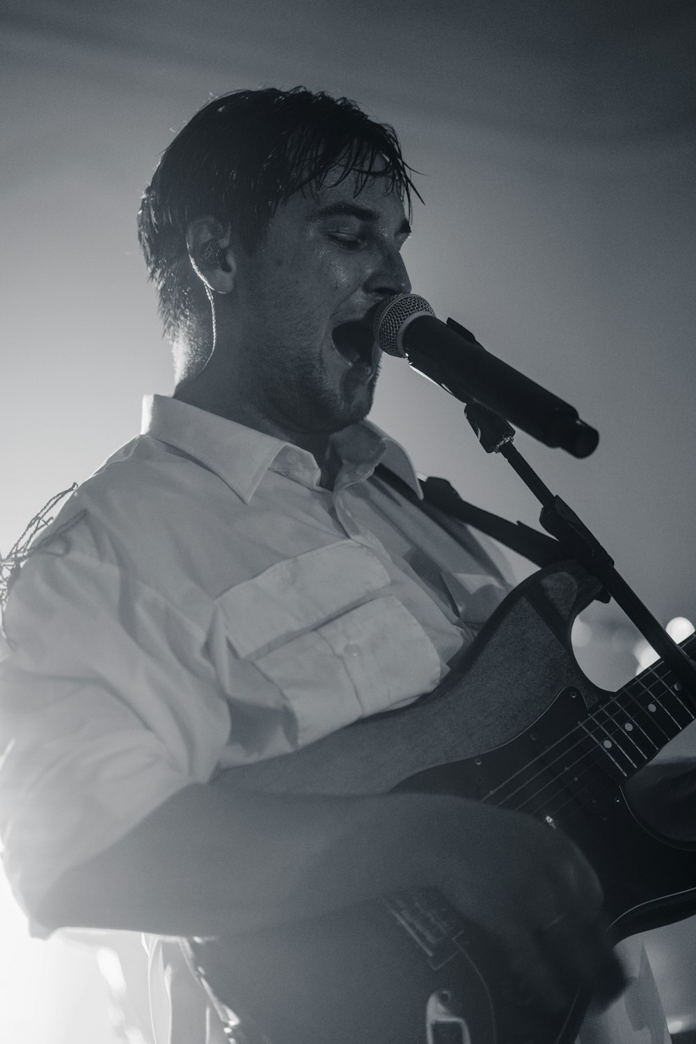 man in white dress shirt playing guitar
