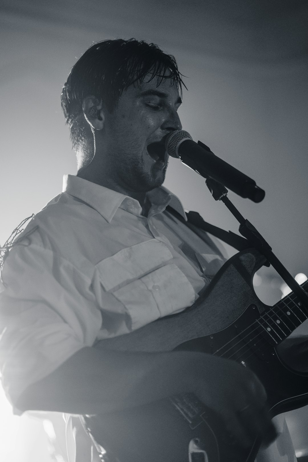 man in white dress shirt playing guitar
