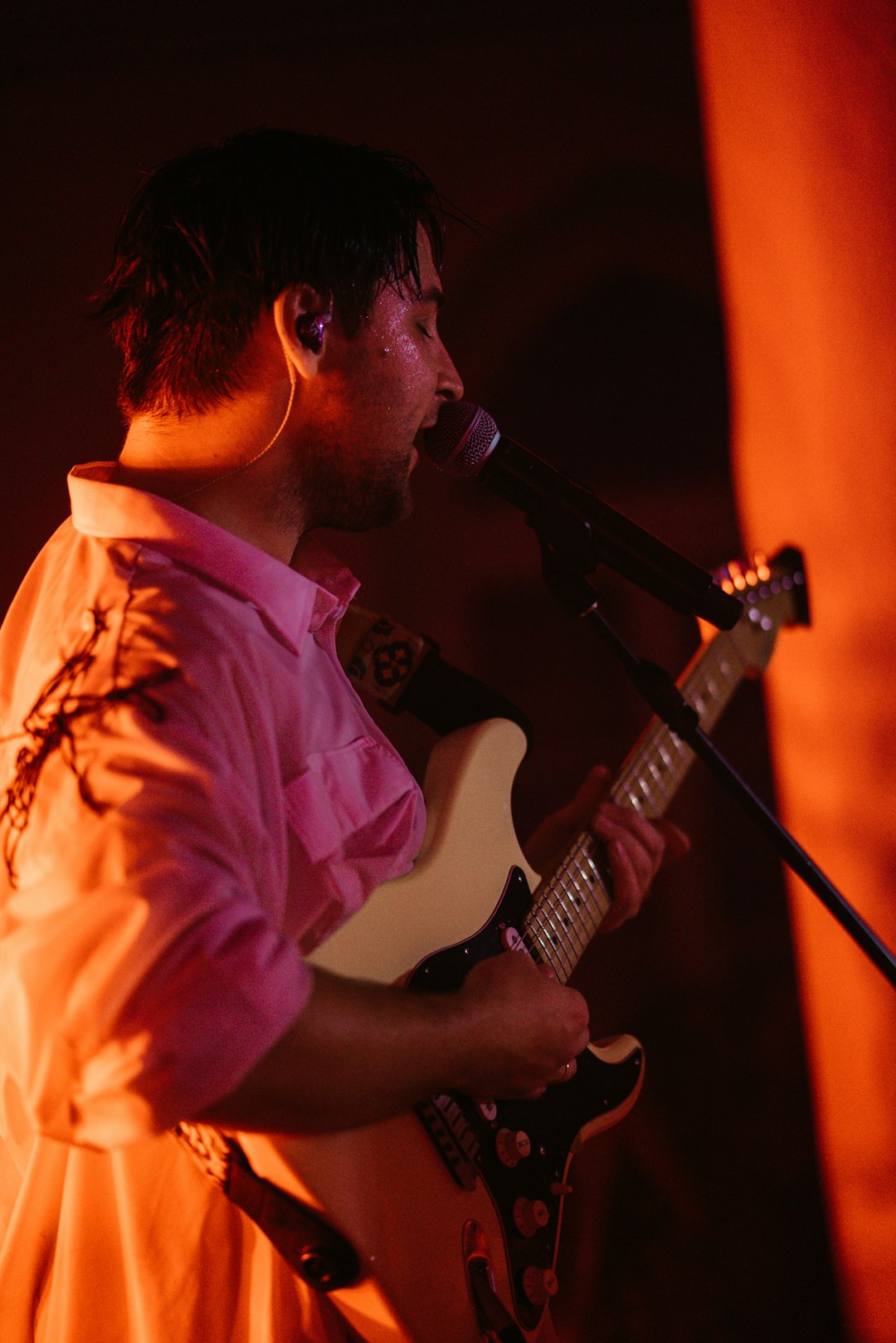 man in white dress shirt playing electric guitar