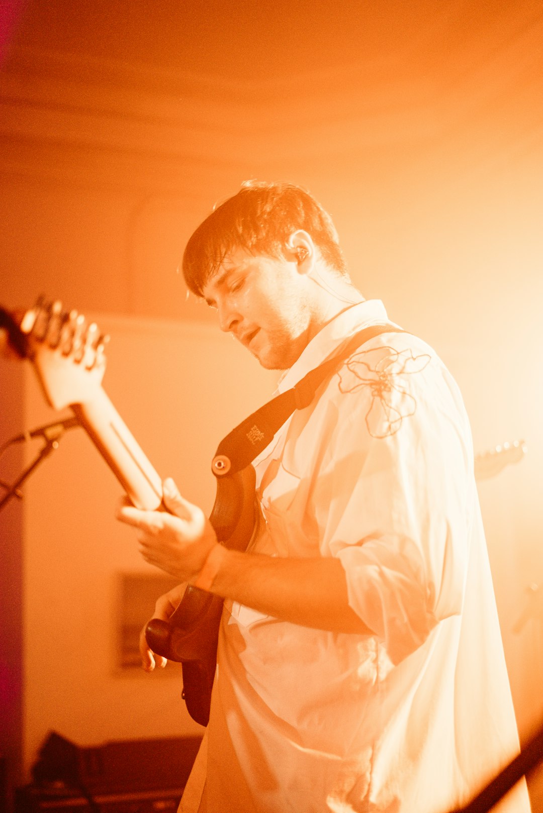 man in white button up shirt playing guitar