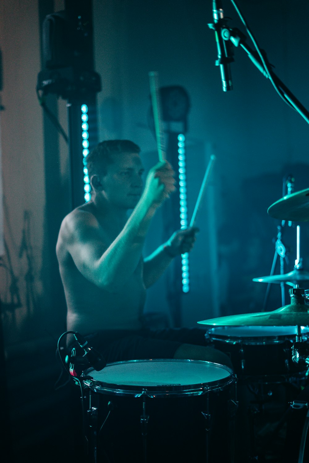 topless man playing drum and drum set
