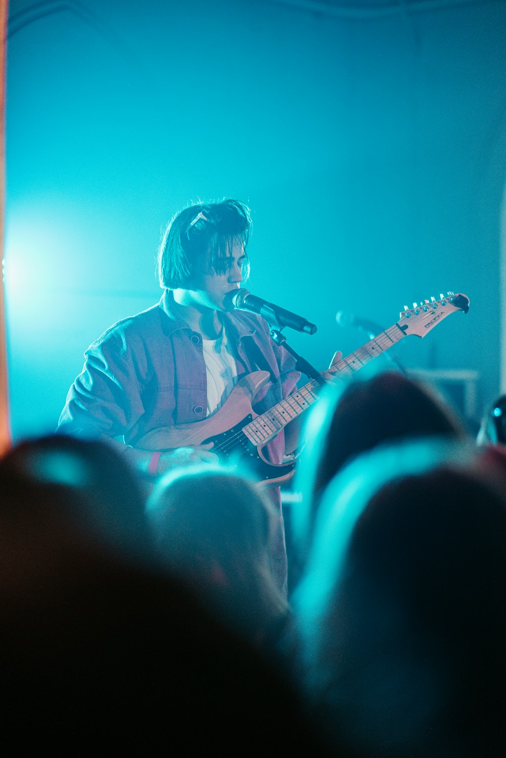 man in red and white plaid dress shirt playing guitar