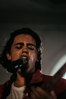 Close-up of Shadmehr singing passionately into the microphone.