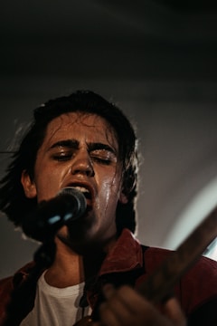 A smoky club scene with a singer gripping the microphone, eyes closed, lost in the music.