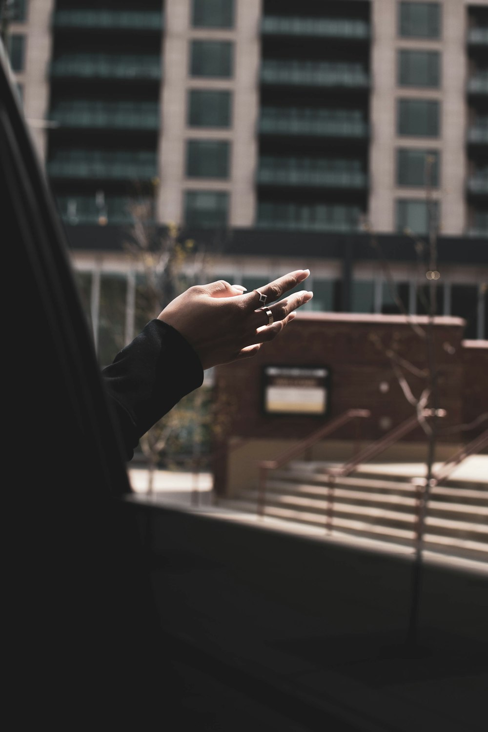 person in black long sleeve shirt holding glass window