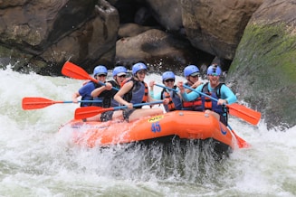 people riding orange kayak on river during daytime