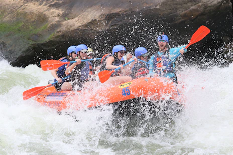 people riding orange kayak on water during daytime