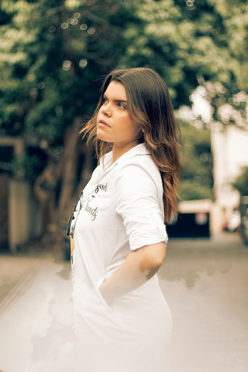 woman in white polo shirt standing on road during daytime