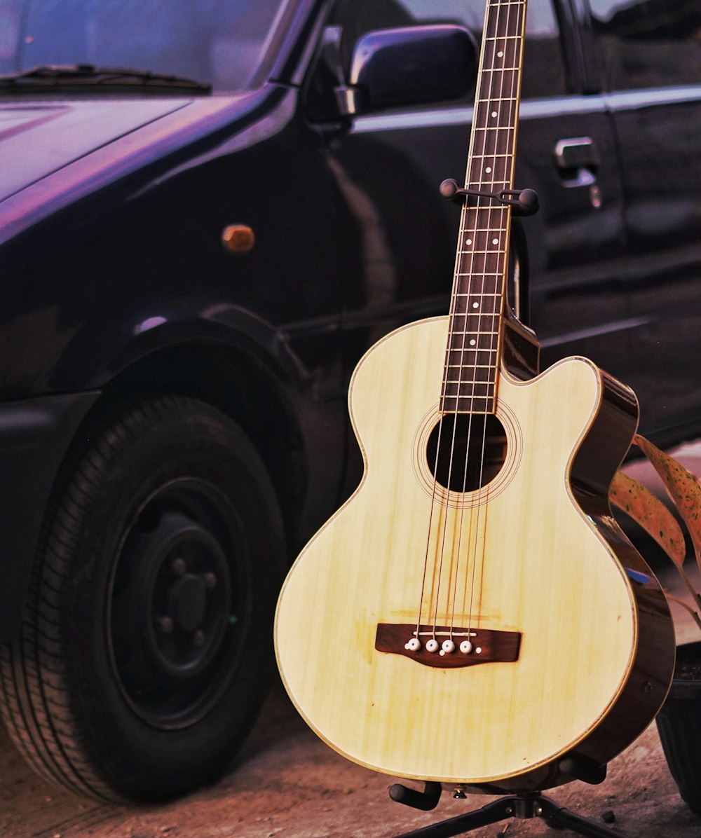 brown acoustic guitar on black car