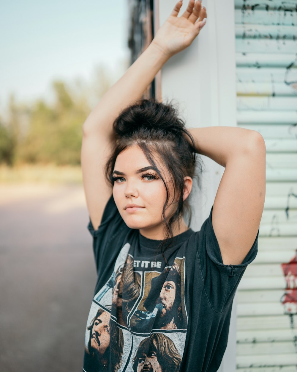 woman in black crew neck t-shirt raising her hands