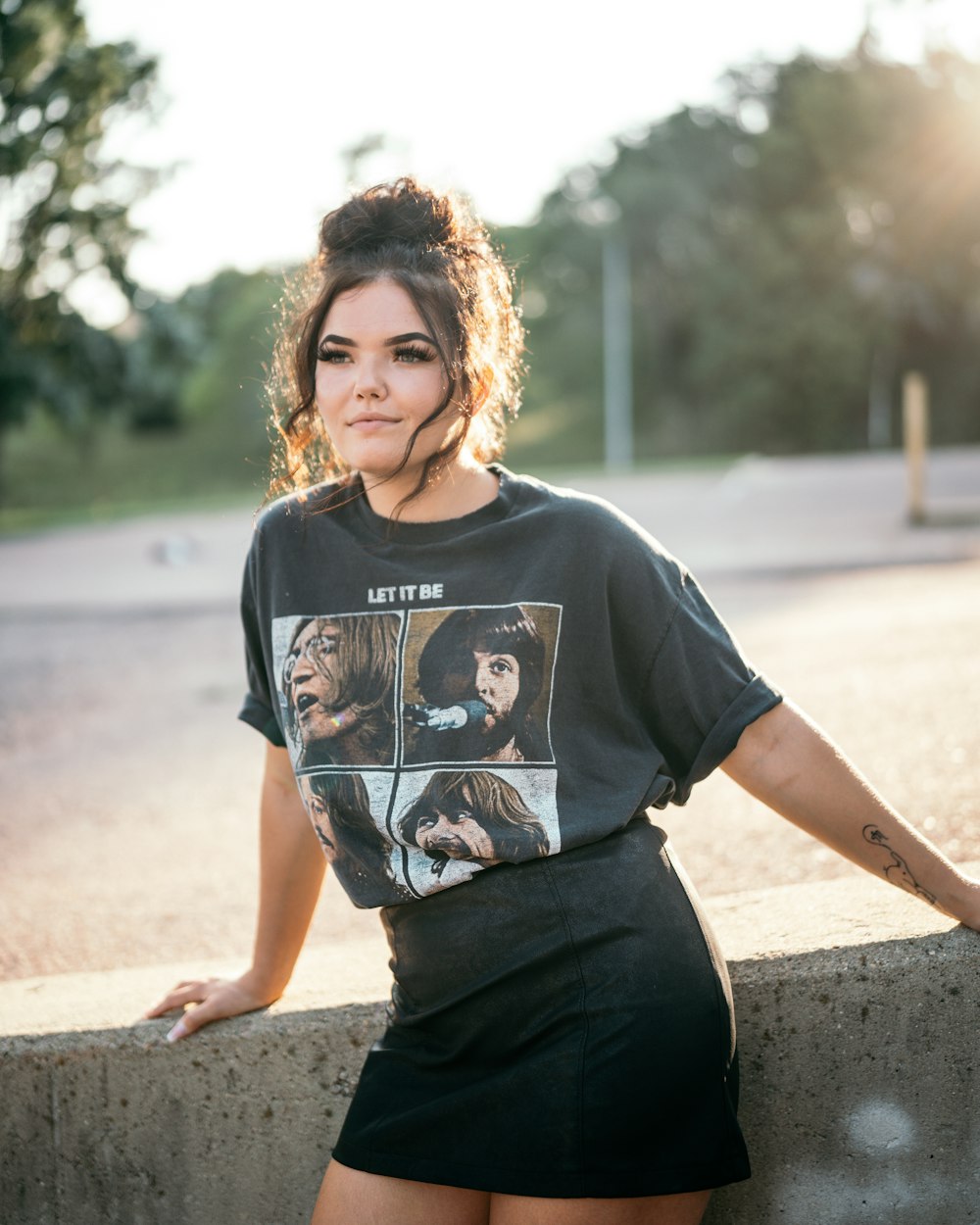woman in black crew neck t-shirt and black pants standing on gray concrete road during