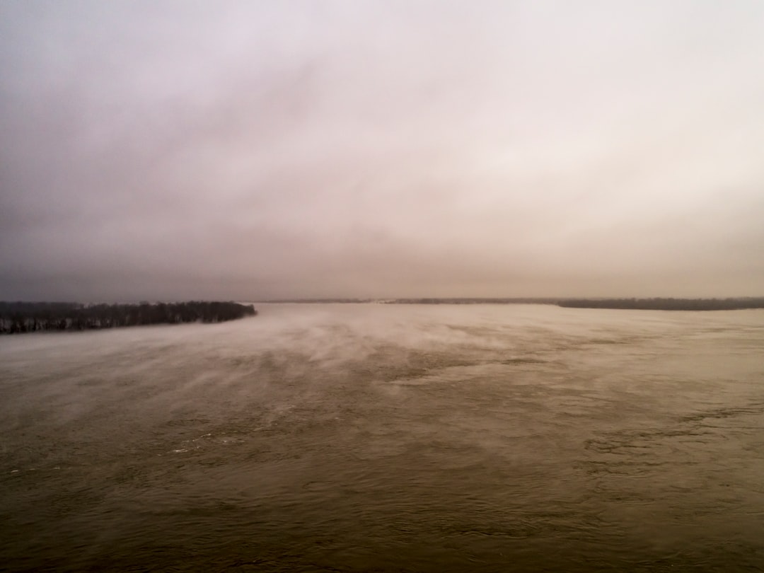 body of water under white sky during daytime