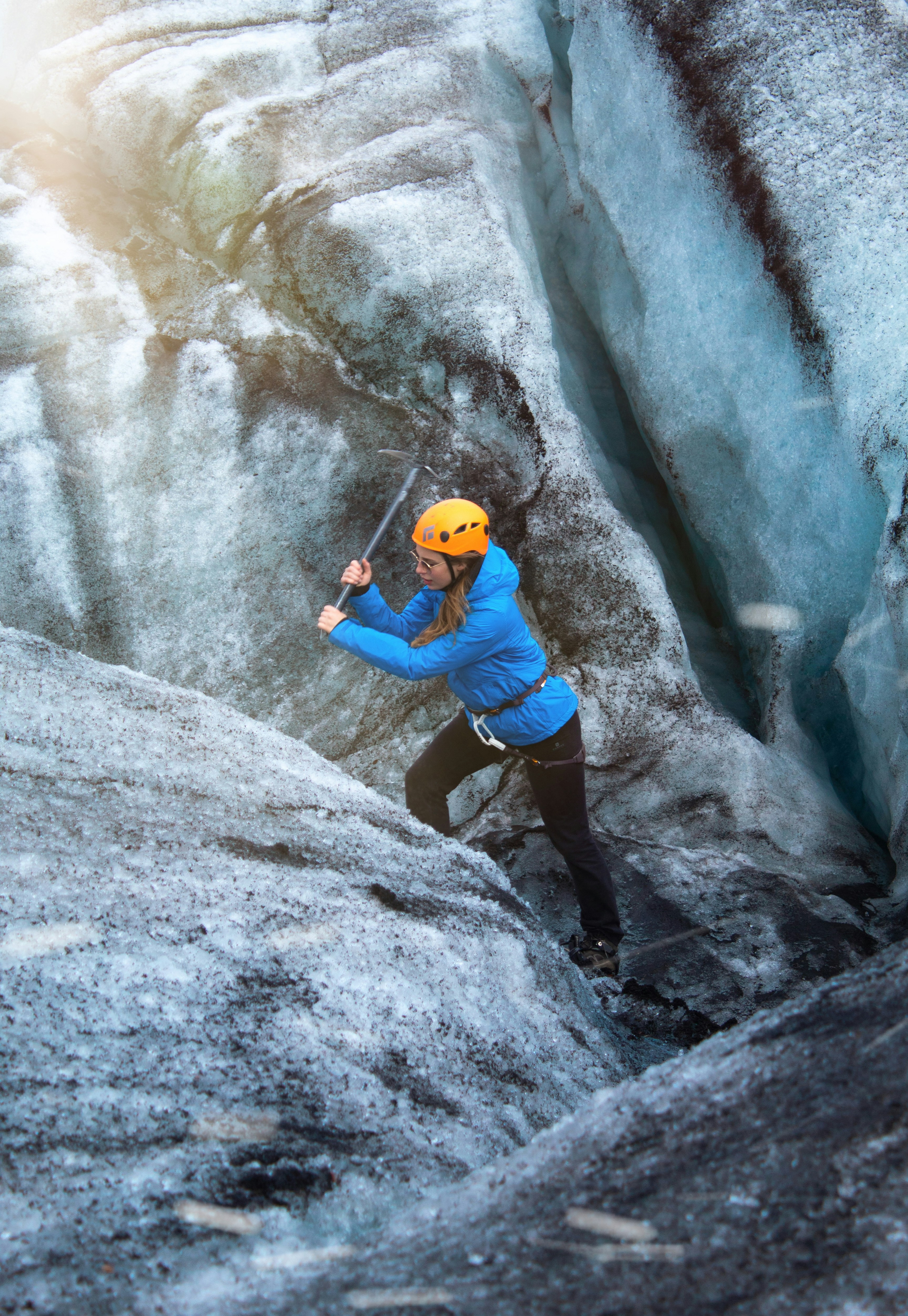 man in blue t-shirt climbing on gray rock